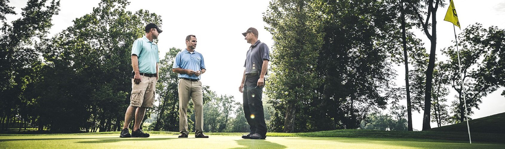 Men having conversation on putting green 